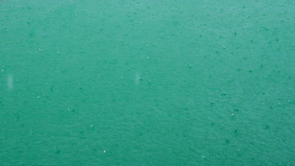 Rain Dropping on Turquoise Lake on Summer Day Raindrops Falling on River Water alt