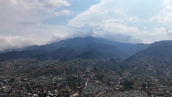 Static aerial hyperlapse of mountains and cemetery outside of San Juan Oscuncalco in Guatemala. alt