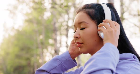 Asian Woman Listening to Music with Headphones alt