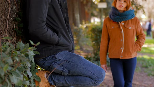 drug dealing.young woman buying dose from the African pusher in the park alt