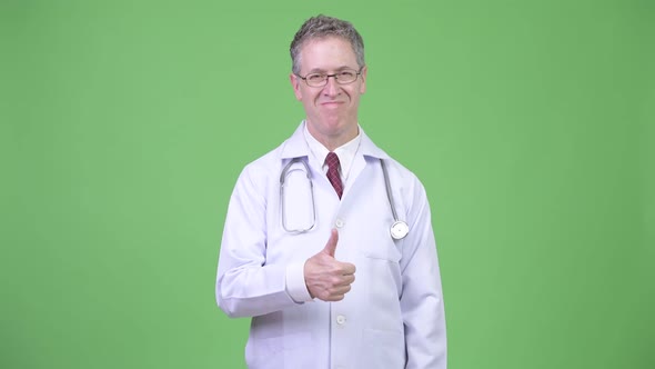 Portrait of Happy Mature Man Doctor Giving Thumbs Up