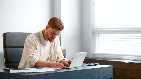 Professional male manager types on white laptop alt