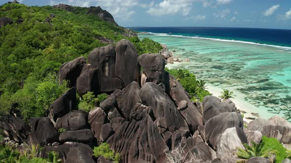 Aerial dolly slowly over black granite boulders of jagged smooth shape alt