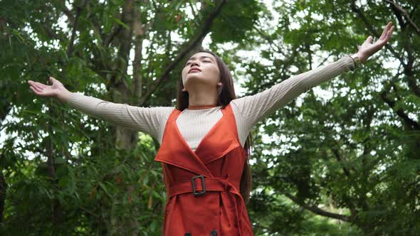 Beautiful Young Woman standing with arms raised enjoy in nature alt