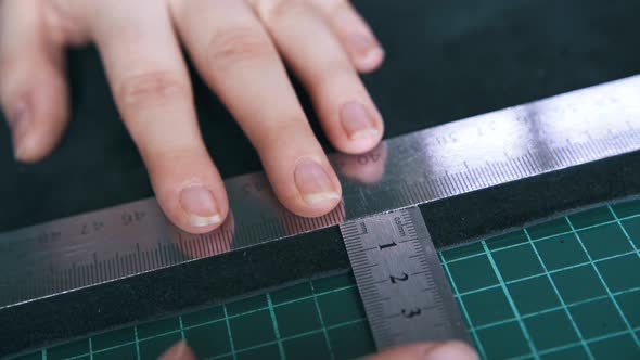 Professional Tailor Measures Leather with Rulers Closeup alt