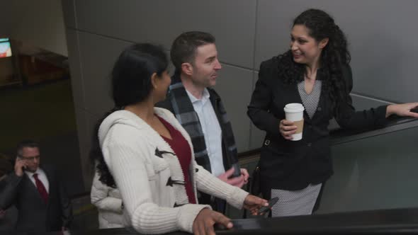 Businesspeople on escalator talking