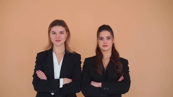 Two Young Business Woman Dressed Black Formal Suit Standing Studio Beige Background Looking Camera alt