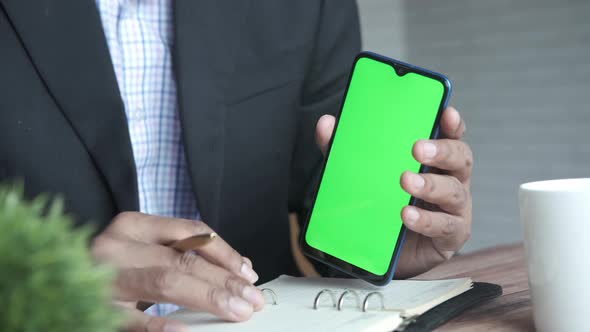 Close Up of Young Man Hand Using Smart Phone with Green Screen