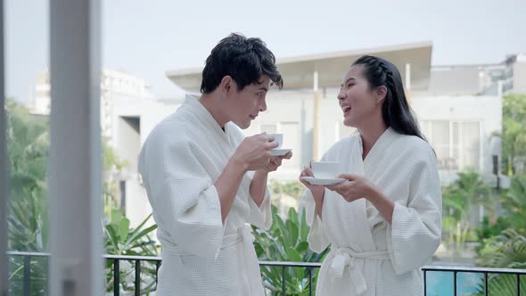 Couple sipping coffee on the balcony of the hotel room on vacation