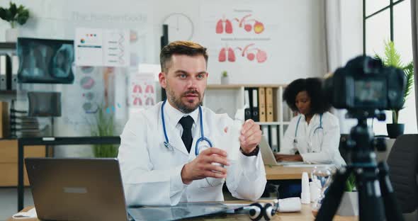 Doctor Telling About Personal Protective Equipment when Record Video on Camera for Internet Audience alt