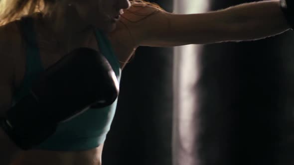 Woman does Muay Thai kickboxing training at the gym. alt