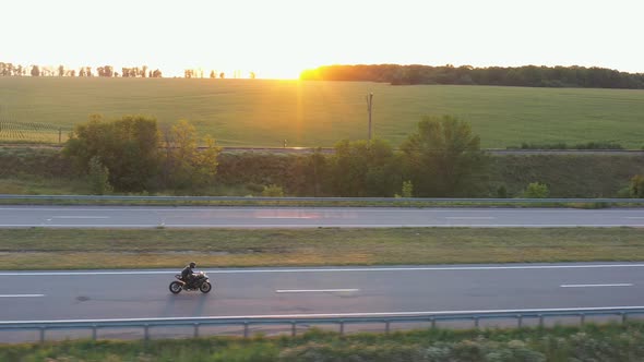 Aerial View to Biker Rides on Modern Sport Motorbike at Highway alt