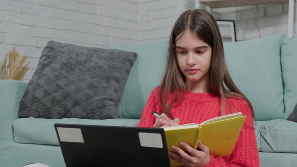 Beautiful Girl Making Notes of Online Lecture Lesson Sitting on the Floor Carpet alt