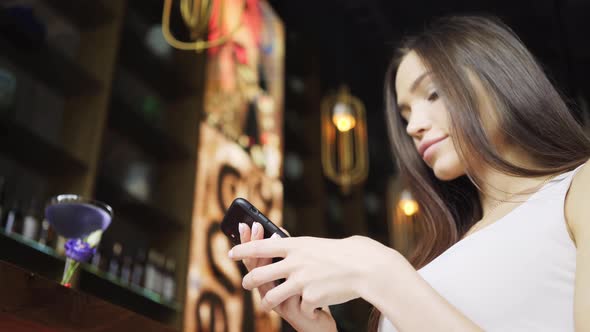 Brunette with Long Loose Hair Types on Black Smartphone