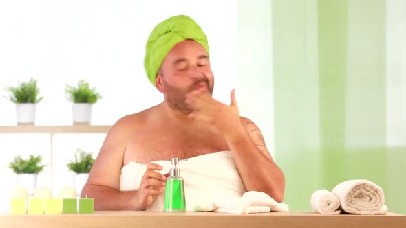 Man Wearing Towel on His Head Drink Lotion