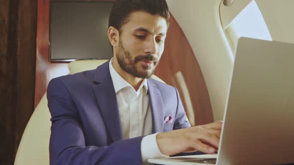 Happy and smiling man working with laptop.