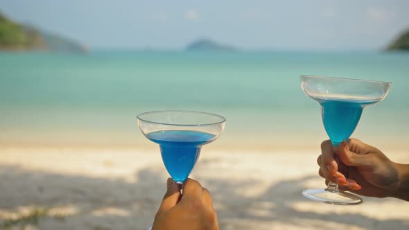 The Love Couple is Holding a Glass of Blue Curacao Cocktail on Sea
