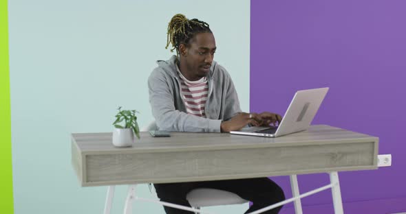 African Businessman Working on Laptop Sitting at Home Office Desk alt