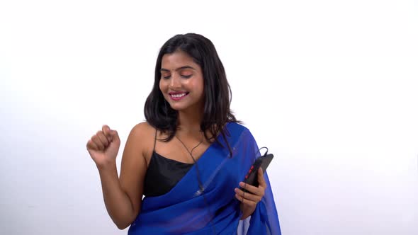 Indian woman in saree listening to music alt