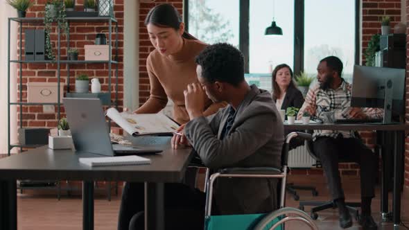 Person with Impairment Brainstorming Ideas with Aisan Woman alt