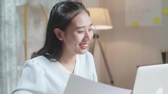 Close Up Of Asian Woman Designer Looking At The Layout Bond While Working With Laptop At The Office alt