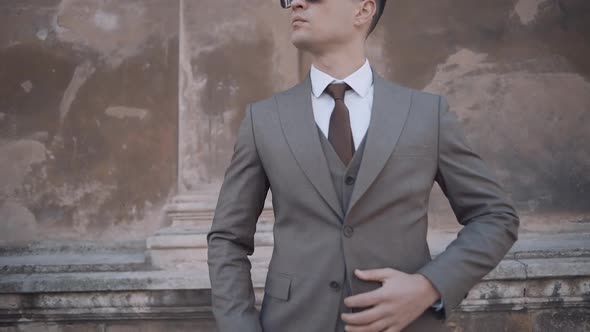 serious businessman walking in suit near modern building. Confident business man in glasses at stree alt