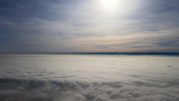 Aerial View From High Altitude of Earth Covered with White Puffy Cumulus Clouds on Sunny Day alt
