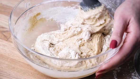 Hands Mixing Cake Batter with a Spatula in a Glass Bowl. - Slider Left alt