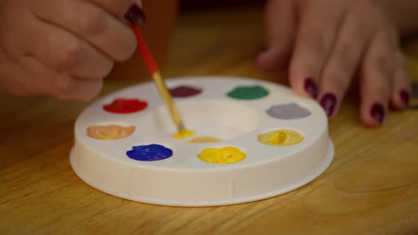 Close Up Beautiful Woman Paints on Wooden Jewelry Bracelet in Art Home Studio alt