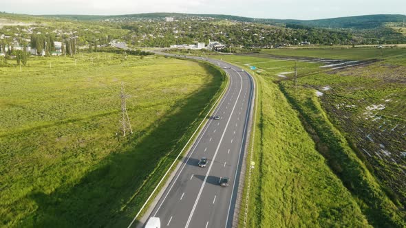 Aerial drone view of a highway with cars, village, a lot of greenery, fields in Moldova alt