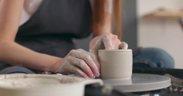 Closeup of Young Woman's Hands in Pottery Studio Using Pottery Wheel Handmade Ceramics Creative alt