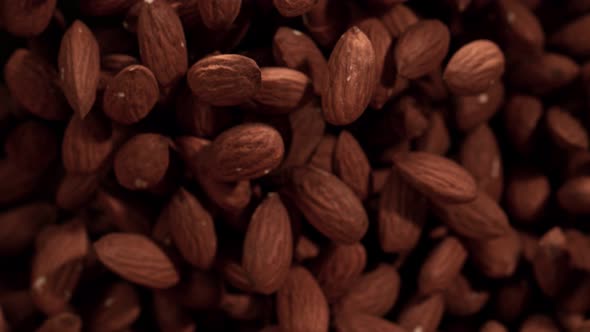 Super Slow Motion Shot of Almonds Flies After Being Exploded Against Black Background 1000Fps alt