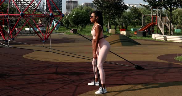 Fit black woman engaged in sports doing fitness training outdoors.
