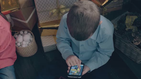 Little Boy in Blue Shirt Plays Mobile Games on Smartphone alt