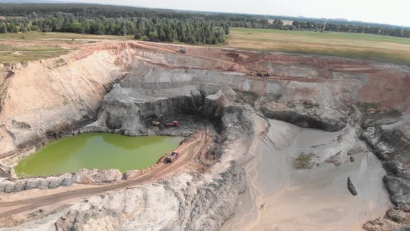 Huge open quarry with mounds of minerals. Machinery excavators digging clay quarry. alt