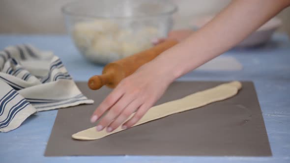 Baker rolling dough . Handmade pastry for patisserie shop.