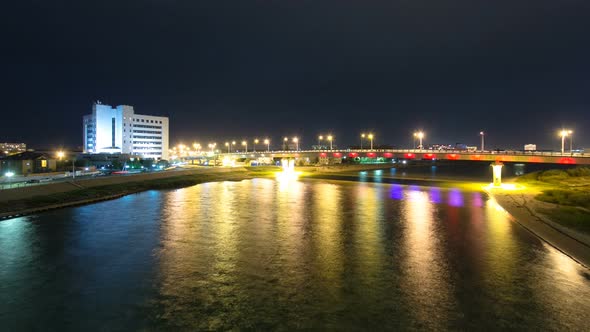 Modern Houses and Illuminated Bridge on the Riverside Ural in City Atyrau Timelapse Hyperlapse alt