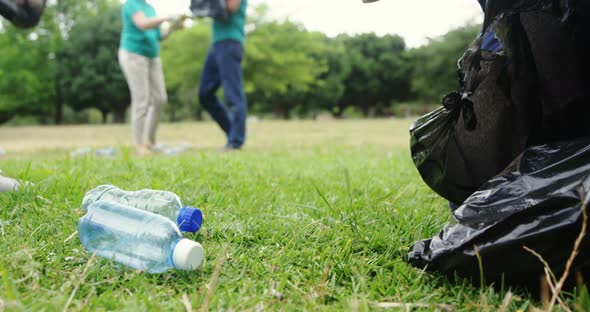 Volunteer collecting litter in the park alt
