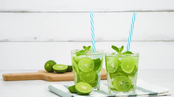Refreshing Mojito cocktail drinks in the glasses with fresh sliced limes