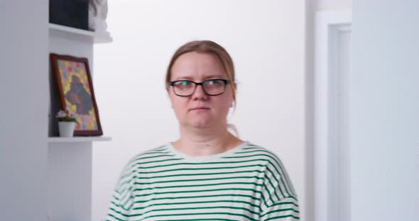 Curvy Woman in Glasses Walks Into Room Showing Discontent
