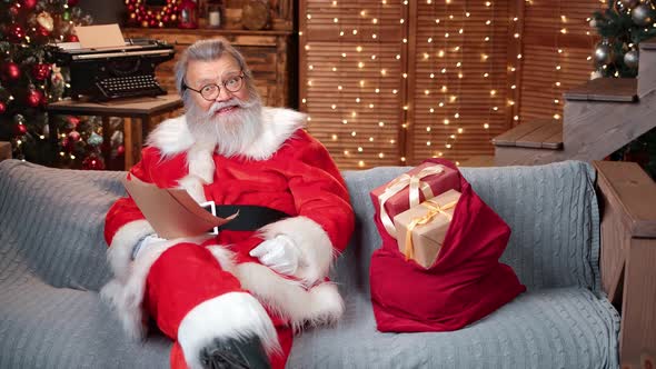 Happy Santa Claus Blogger Reading Christmas Gift Wish List alt