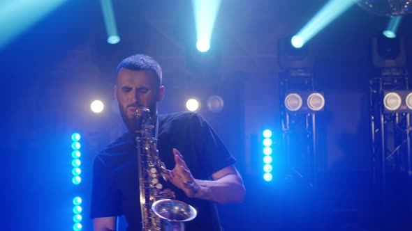 Live Performance of Saxophonist Man with Saxophone Dancing on Concert Musician Stage with Lights alt