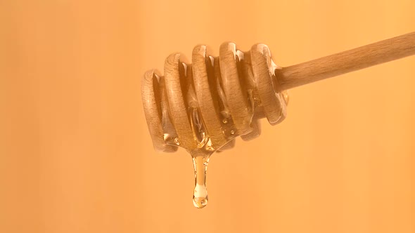 Liquid Organic Honey Dripping from a Honey Dipper on a Light Background. Healthy Food Concept alt