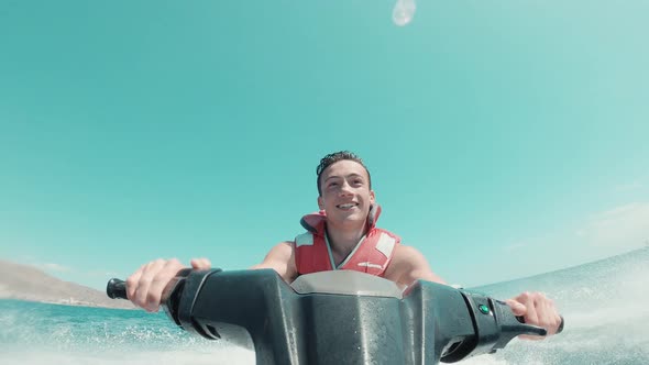Teenager man enjoying summer in a jet ski in the middle of the sea having fun racing alone alt