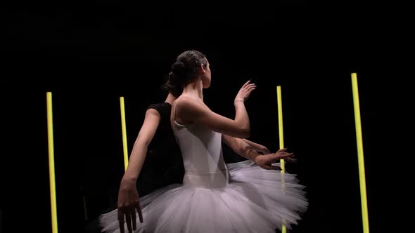 Camera Circular Motion Around Young Ballerinas Dancing on a Black Studio Background with Bright Neon alt