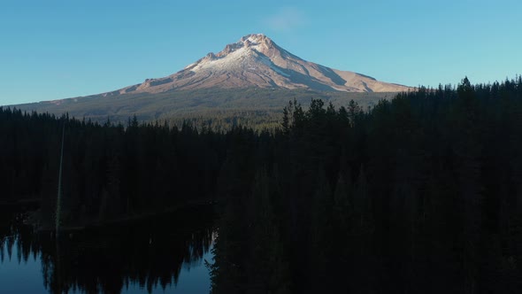 Aerial crane shot revealing Mt. Hood seen from Trillium Lake at sunset in Oregon. alt