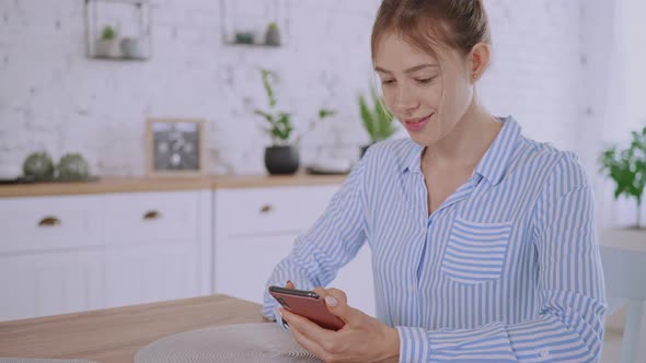 Female Chatting Using Mobile at Home