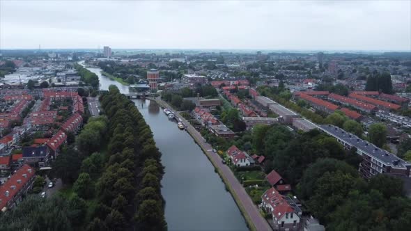 Aerial shot of boat on river flowing through city in the Netherlands alt