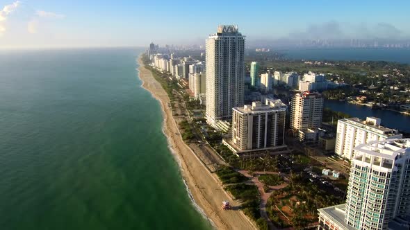 Aerial Footage above the sea viewing the Miami beach during golden hour