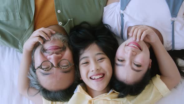 Asian family mom dad and cute son child laying laugh smile on white soft be